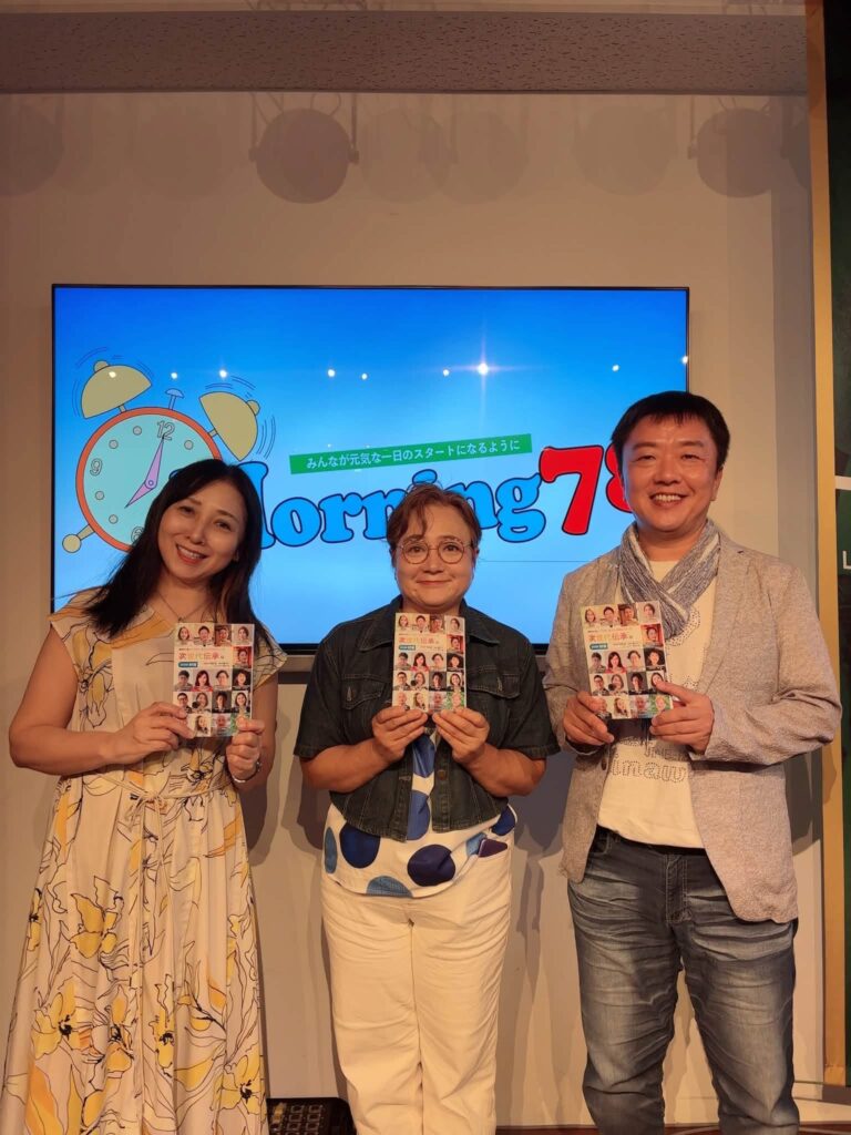 FM那覇「Morning 78」のスタジオで『次世代伝承版2026秋号』を手にした橘さゆりさん、石井紀伊子さん、平間正彦の記念撮影